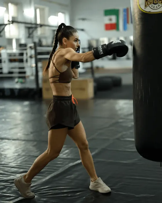 Спортсменка отрабатывает удар по мешку в BronxGym
